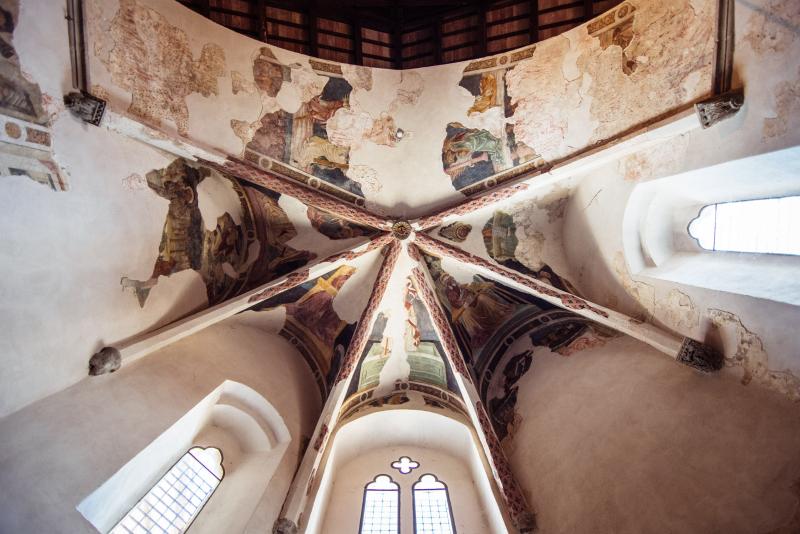 Frescoed vaults of the Church of San Francesco in Montone, with medieval sacred scenes and Gothic windows.