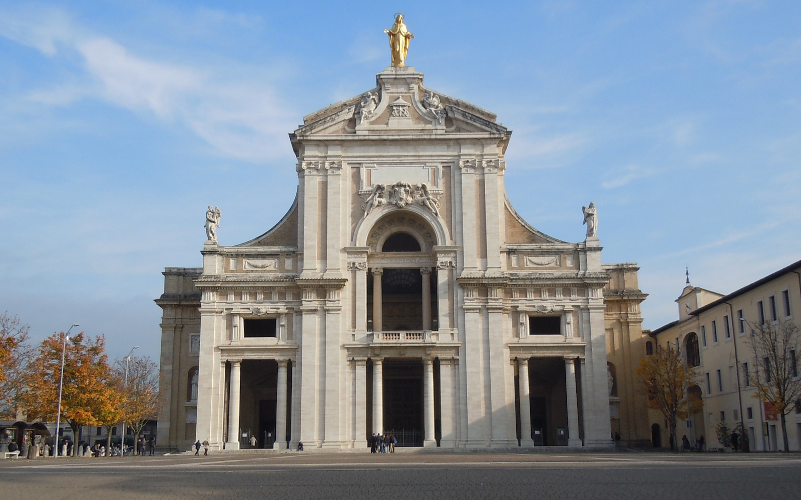 Facciata della Basilica di Santa Maria degli Angeli ad Assisi, con la statua dorata della Madonna sulla sommità.