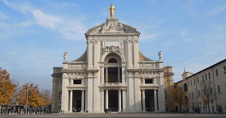 Façade of the Basilica of Santa Maria degli Angeli in Assisi, with the golden statue of the Madonna at the top.