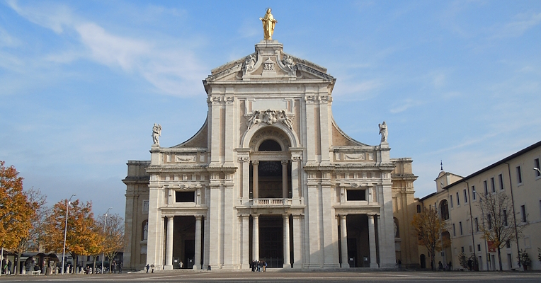 Façade of the Basilica of Santa Maria degli Angeli in Assisi, with the golden statue of the Madonna at the top.