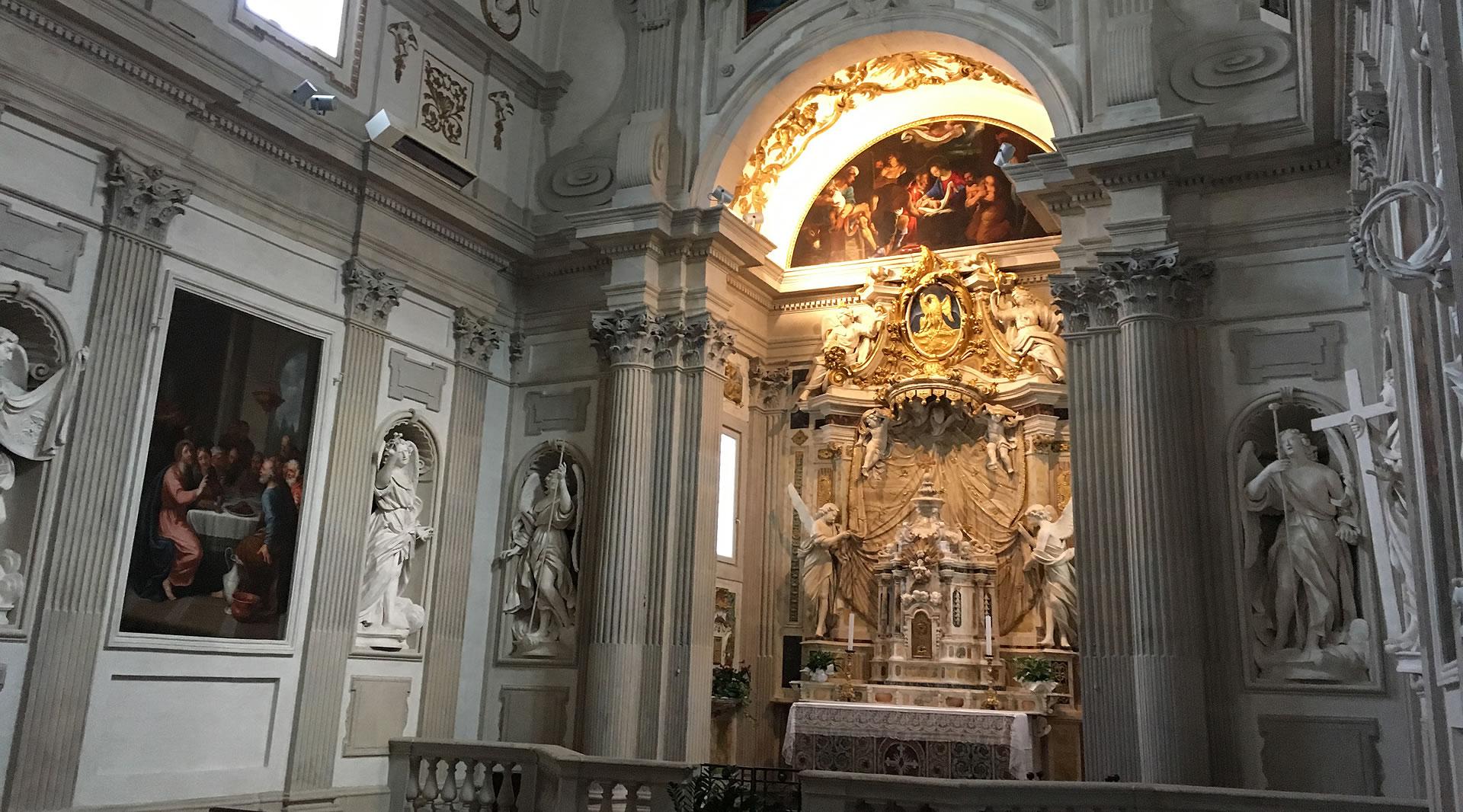 Chapelle baroque dans la cathédrale de Spolète, avec autel décoré, sculptures, colonnes, peintures et une fresque illuminée en hauteur.