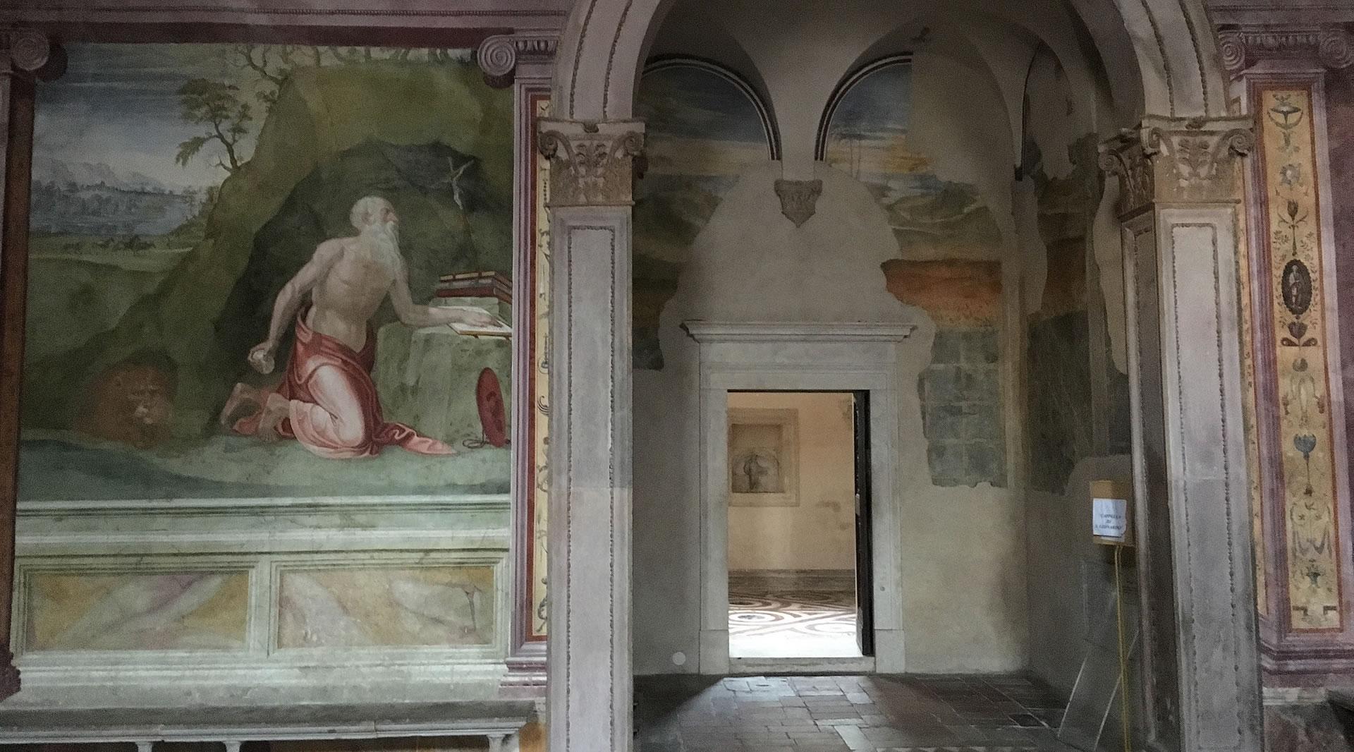 Fresque Renaissance dans la cathédrale de Spolète représentant saint Jérôme en prière, colonnes décorées et porte ouverte sur une autre salle.