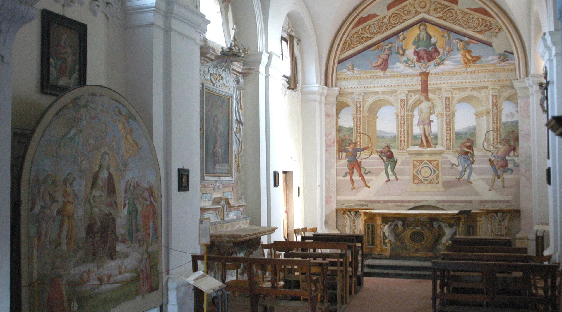 Interior view of the church: on the left wall, there is a painting of the Madonna delle Grazie, while the pews are arranged in the center of the nave. In the background, behind the altar, is Perugino's masterpiece, "The Martyrdom of San Sebastiano."
