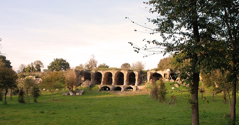 Monumental remains of the great substructures of Ocriculum, with arches carved into the rock and surrounding vegetation
