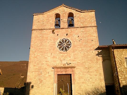 Facciata in pietra della Chiesa di San Giovanni a Vallo di Nera con campanile a vela a due campane e rosone centrale