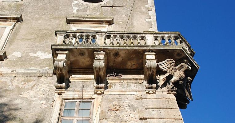 Balcone in pietra del Castello di Giove con mensole scolpite e un’aquila decorativa sulla facciata.