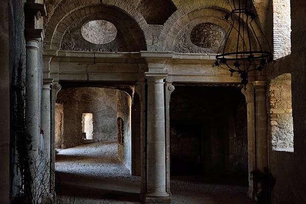 Interno del Castello di Giove con arcate in pietra, colonne e luce che entra da una finestra.