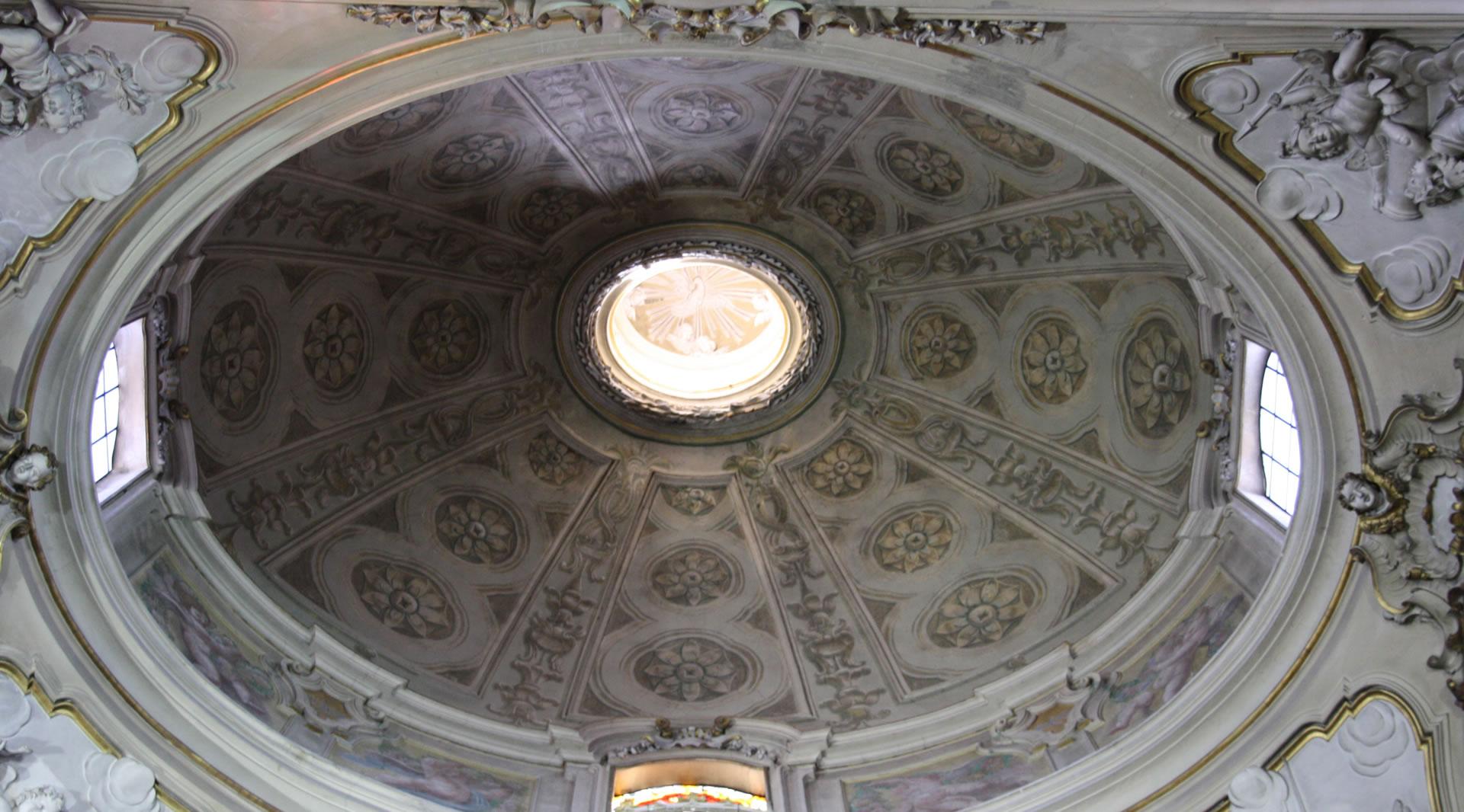 Cupola decorata della chiesa di San Francesco ad Amelia con motivi floreali, stucchi barocchi e lucernario centrale luminoso.