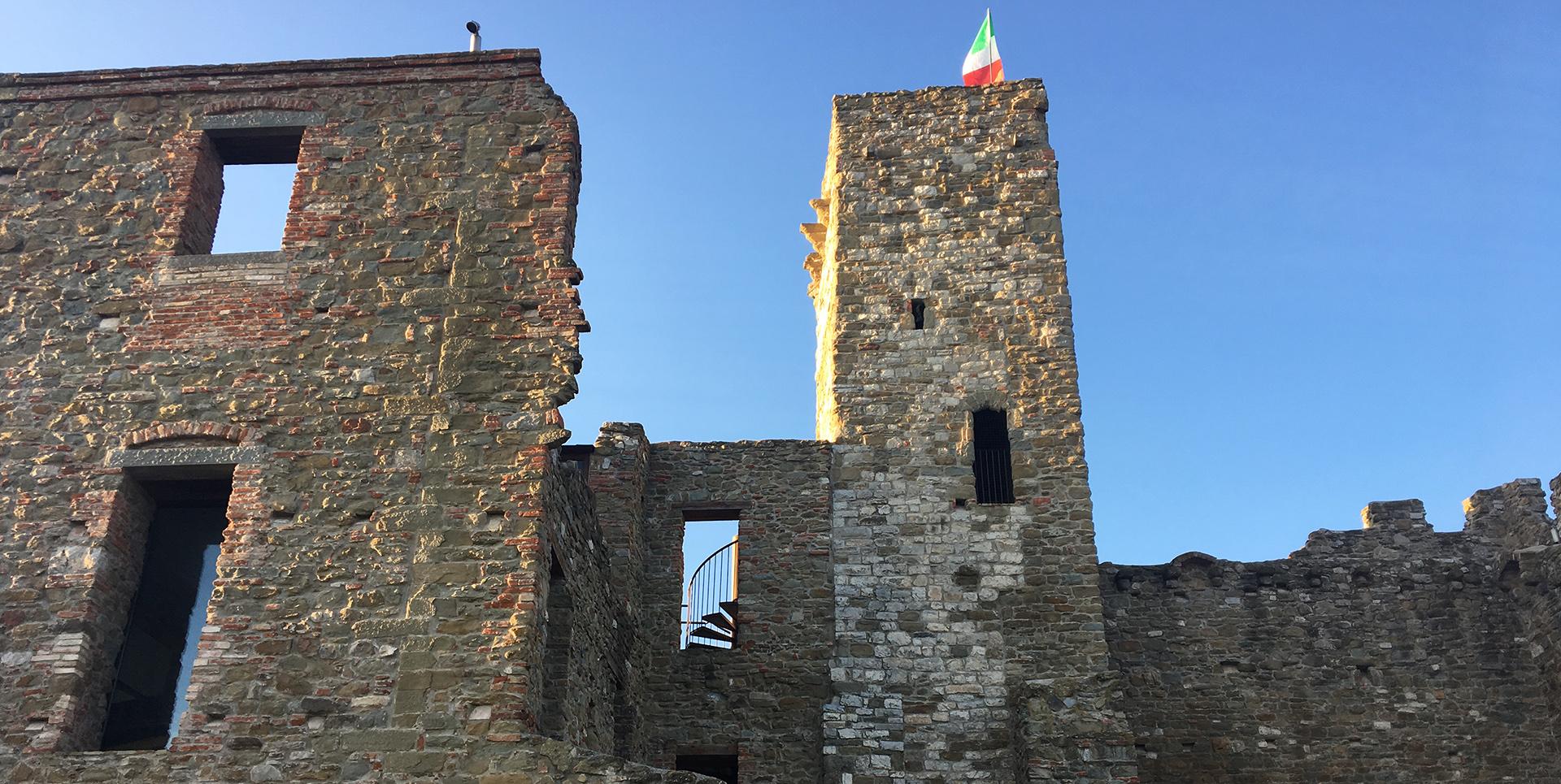 Side perspective of the walls of the Rocca, accompanied by the view of its torrione.
