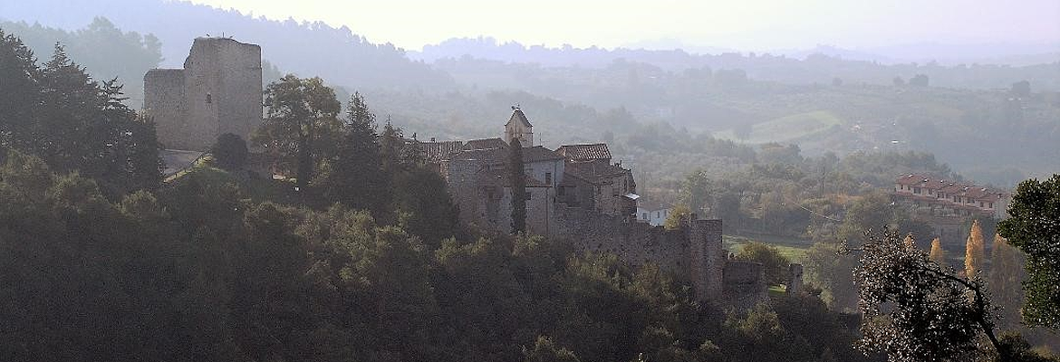 Poggio di Otricoli, antico borgo fortificato, si staglia tra i boschi umbri e le colline avvolte dalla foschia.
