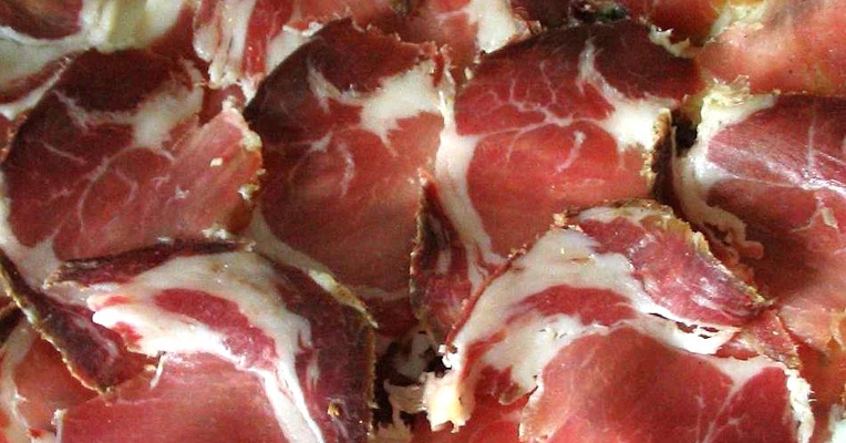 Capocollo-Scheiben mit der charakteristischen roten Farbe des Fleisches und den weißen Fettadern