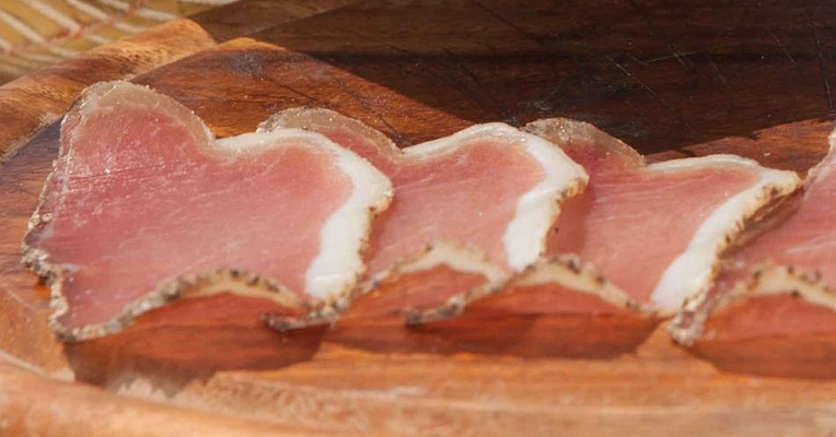 Slices of lombetto with the characteristic uniform pinkish-red colour of the meat and the thin white fat edge