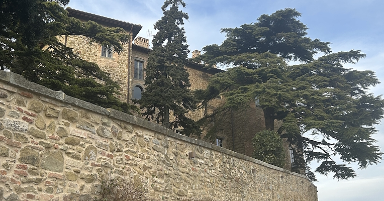 Vue latérale du château de Montesperello, avec ses impressionnants murs d’enceinte et ses structures anciennes reconstruites.