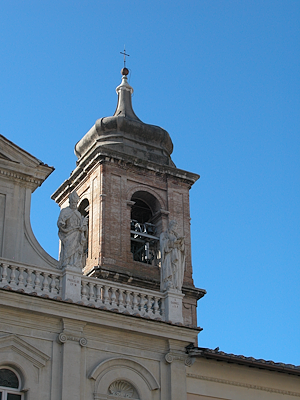Primo piano della torre campanaria della Cattedrale di Santa Maria Assunta a Terni, con la cupola barocca e due statue di vescovi posti ai lati su una balaustra.