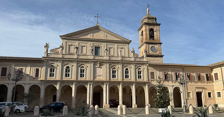 Vista frontale della Cattedrale di Santa Maria Assunta a Terni, con un portico, statue di vescovi sulla balaustra superiore e la torre campanaria a destra, con il piazzale antistante il duomo