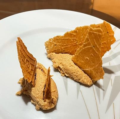 Glace sur une assiette blanche garnie de gaufrettes cassées et croustillantes.