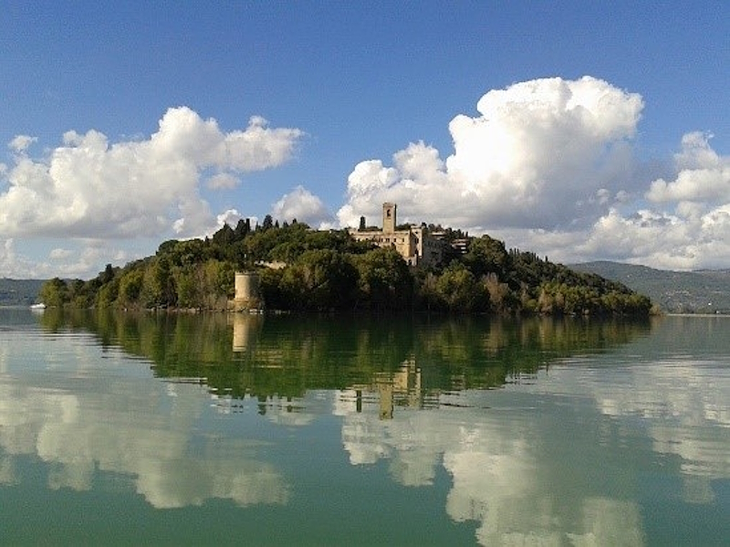 Veduta dell’Isola Maggiore sul Lago Trasimeno sotto un cielo con nuvole.