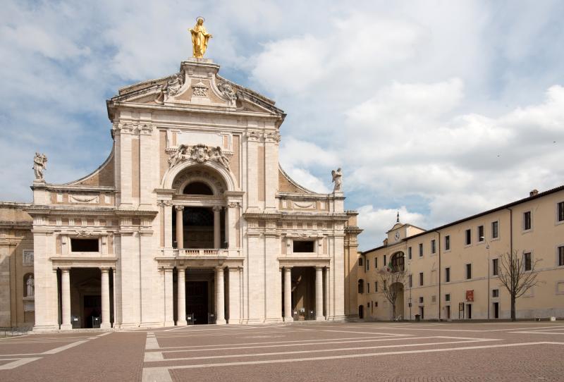 Façade of the Basilica of Santa Maria degli Angeli in Assisi with the square in front and cloudy sky
